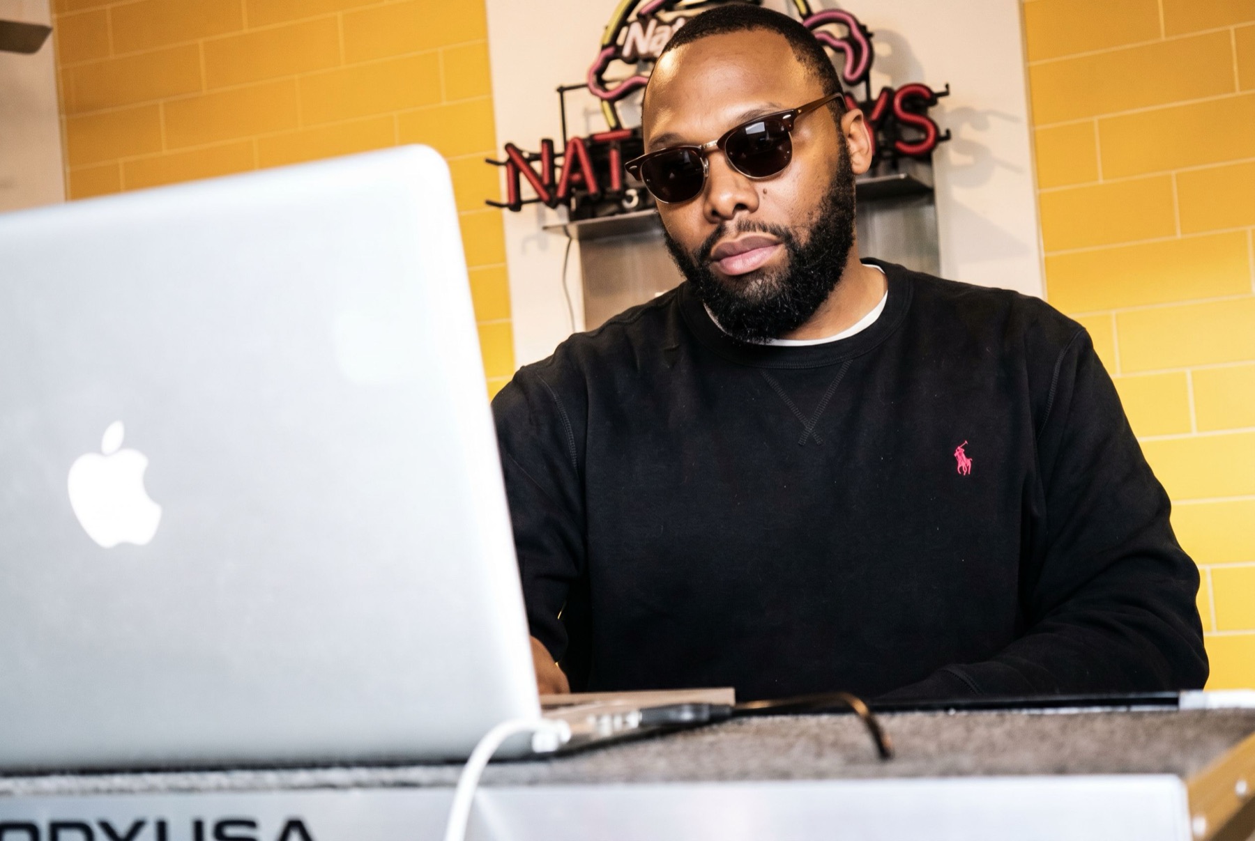 DJ Impeccable working behind a laptop at an event